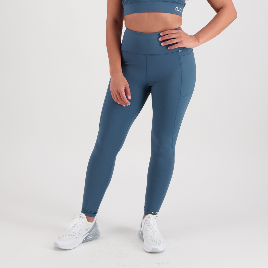Front view. Model legs in full-length leggings in deep, dusty teal colour