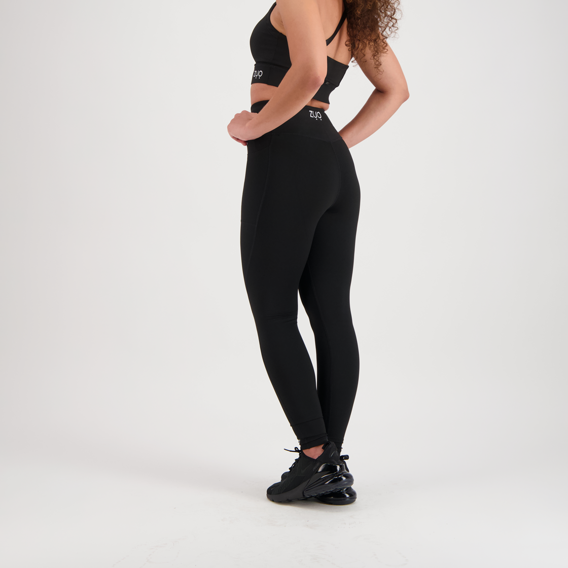View from 3/4. Model legs in full-length leggings in black